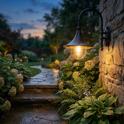 Trompette gooseneck lantern on a stone garden wall along a pathway at dusk