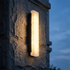 Onyx Outdoor LED Wall Light close-up on a textured stone facade at blue hour