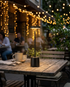 Lumen black cordless LED table lamp on an outdoor cafe table