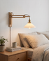 Bjork Glass Wall Sconce in Rubberwood in a bedroom