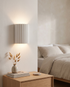 Momo Wall Sconce in White in a bedroom