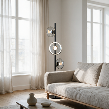 Juniper Floor Lamp in Black and Smoke Gray behind a linen sofa in a bright apartment