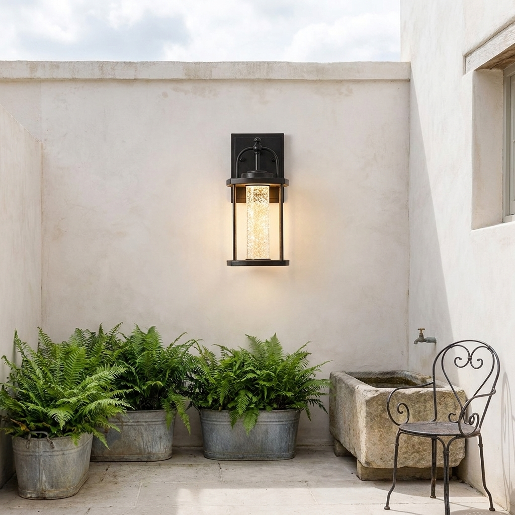 Geometric outdoor wall sconce on plaster courtyard wall with fern planters and water trough