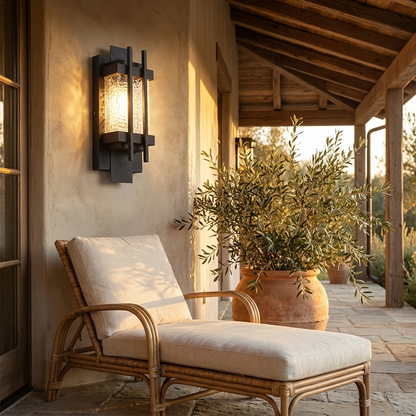 Perrine black LED outdoor wall sconce lighting a covered porch with rattan seating