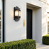 Perrine minimalist steel outdoor wall sconce on a rendered house facade beside a black front door