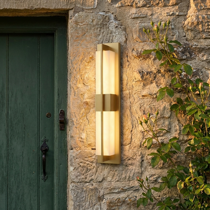 Anseau linear outdoor wall light on a stone cottage wall beside a climbing rose