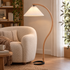 Caprani Beech Wood Linen Floor Lamp with White shade, close-up beside an armchair