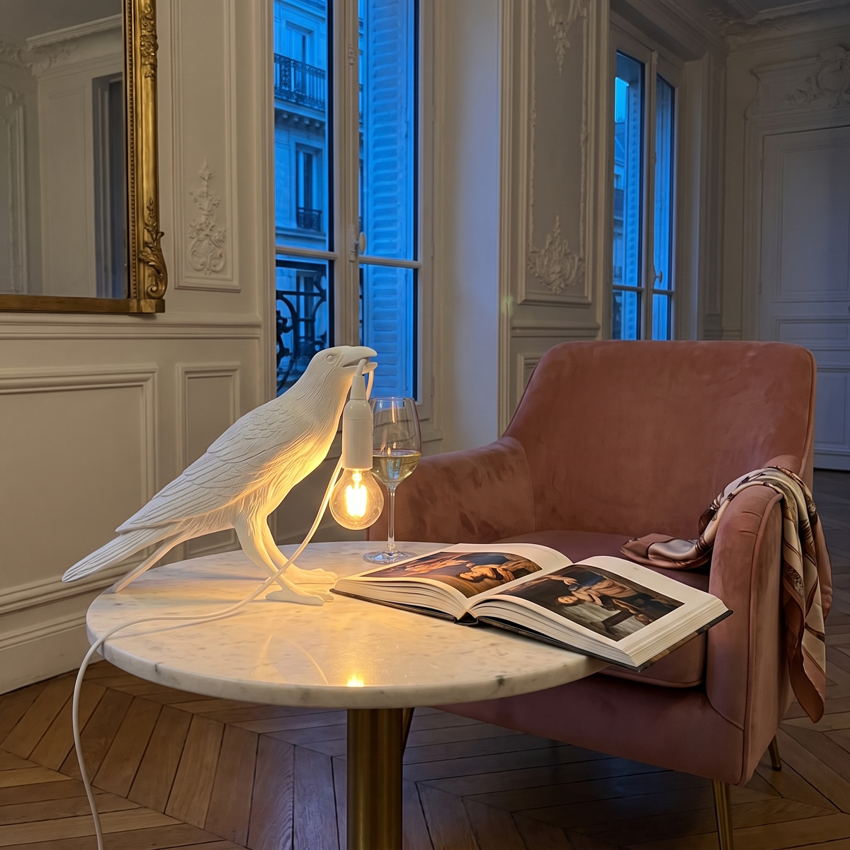 Corbeau white upright raven table lamp in a Parisian reading corner
