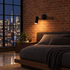 Tilda swing arm wall sconce in black beside the bed in a Manhattan loft bedroom