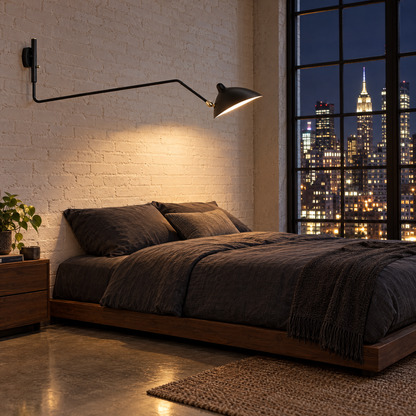 Rivoli swing arm wall sconce in Black, single arm in a Manhattan loft bedroom