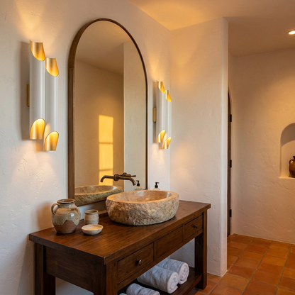 Solenne large double white and gold wall sconces flanking a powder room mirror