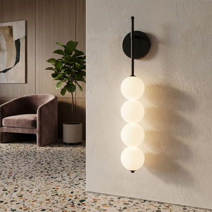 Berenice black wall sconce in the lobby of a boutique hotel with terrazzo floors