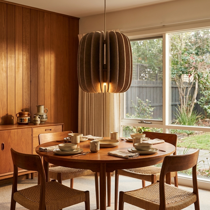 Lamelle oval brown pendant light above the dining table of a mid-century ranch home
