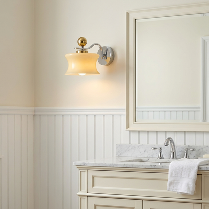 Lucienne Glass Drum Wall Sconce in Beige beside a bathroom mirror